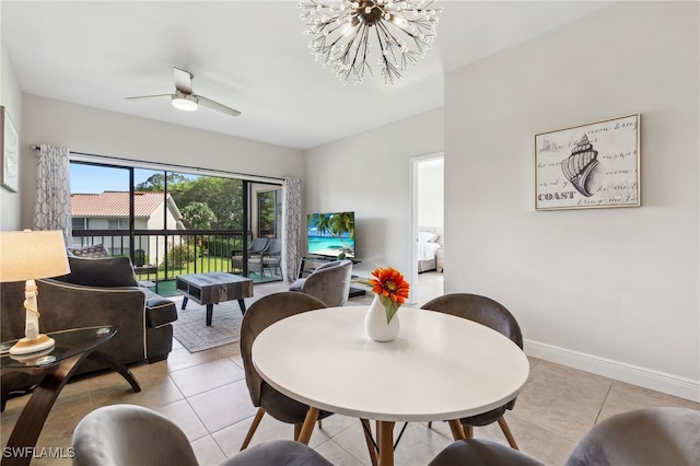 dining room featuring light tile patterned floors, baseboards, and ceiling fan with notable chandelier