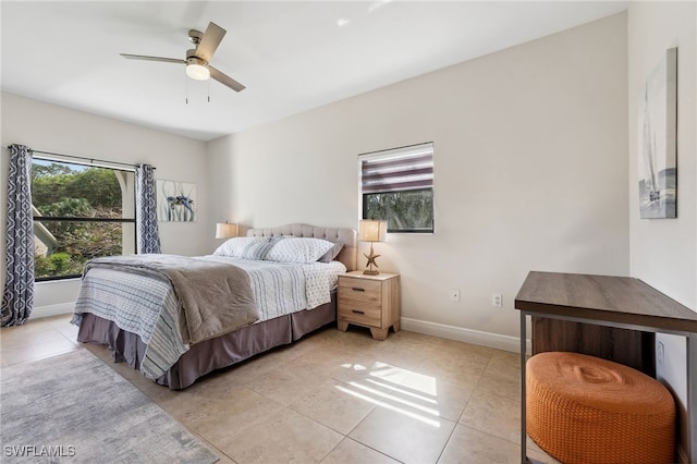 bedroom with light tile patterned floors, multiple windows, and baseboards