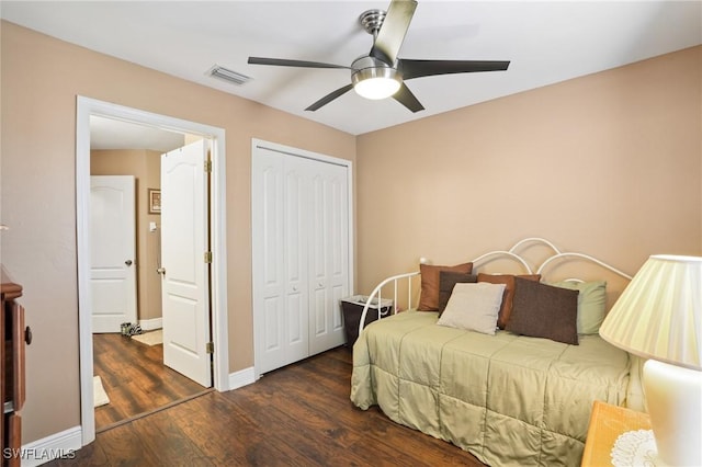 bedroom with a closet, visible vents, baseboards, and wood finished floors