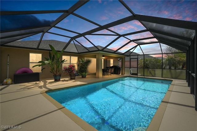 outdoor pool with glass enclosure and a patio area