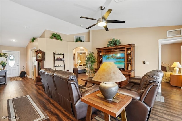 living area featuring lofted ceiling, arched walkways, wood finished floors, and visible vents