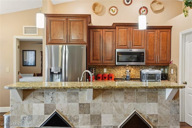 kitchen with a sink, vaulted ceiling, stainless steel appliances, and backsplash