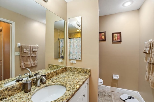 full bath featuring toilet, tile patterned floors, vanity, and baseboards