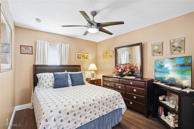 bedroom with dark wood-style floors, baseboards, and a ceiling fan