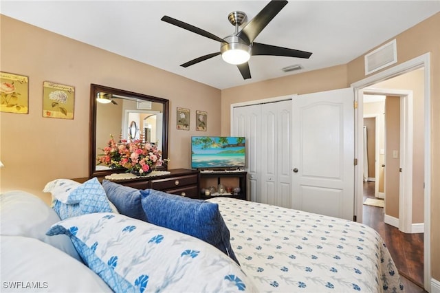 bedroom with a ceiling fan, a closet, visible vents, and dark wood finished floors