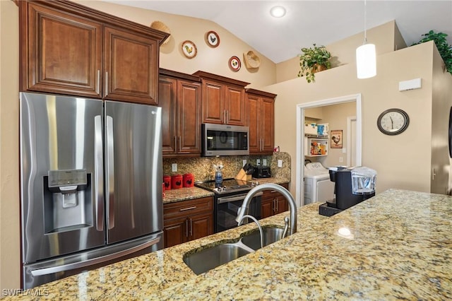 kitchen with washer and clothes dryer, backsplash, appliances with stainless steel finishes, vaulted ceiling, and a sink