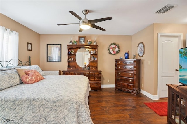 bedroom with dark wood-type flooring, a ceiling fan, visible vents, and baseboards