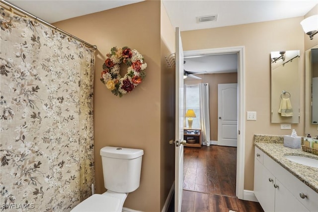 full bathroom with baseboards, visible vents, toilet, wood finished floors, and vanity