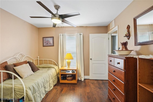 bedroom featuring ceiling fan, visible vents, and dark wood-style flooring