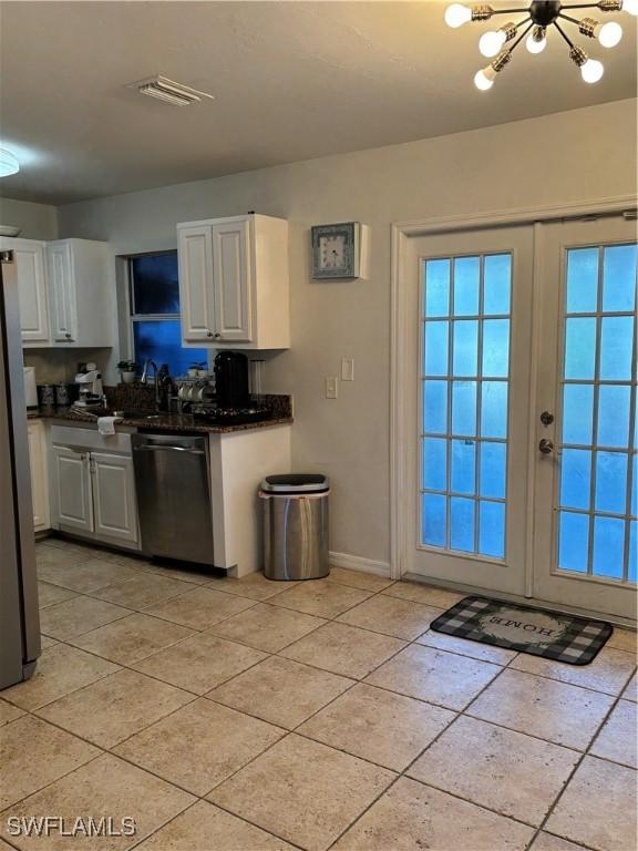 kitchen with light tile patterned floors, white cabinetry, baseboards, french doors, and appliances with stainless steel finishes