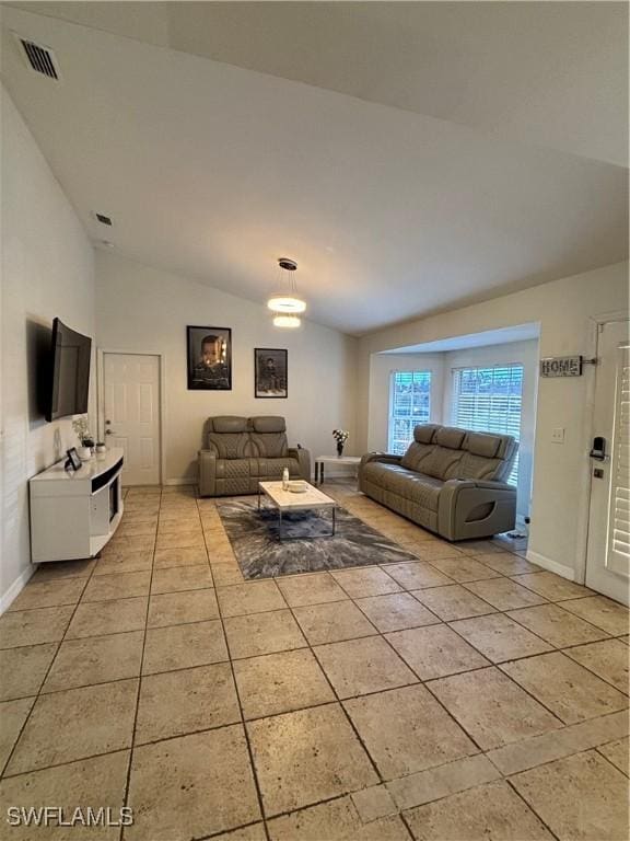 living area with visible vents, vaulted ceiling, baseboards, and light tile patterned floors