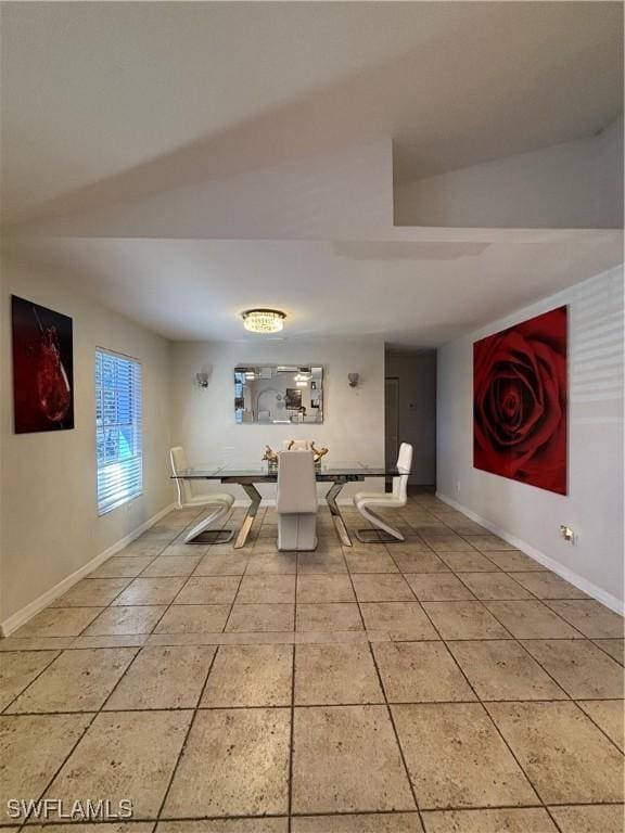 unfurnished dining area featuring light tile patterned floors and baseboards