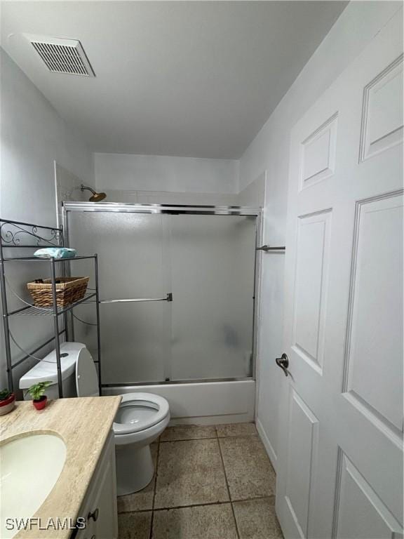 full bathroom featuring enclosed tub / shower combo, visible vents, vanity, and toilet