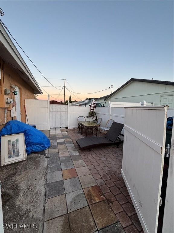 patio terrace at dusk featuring fence