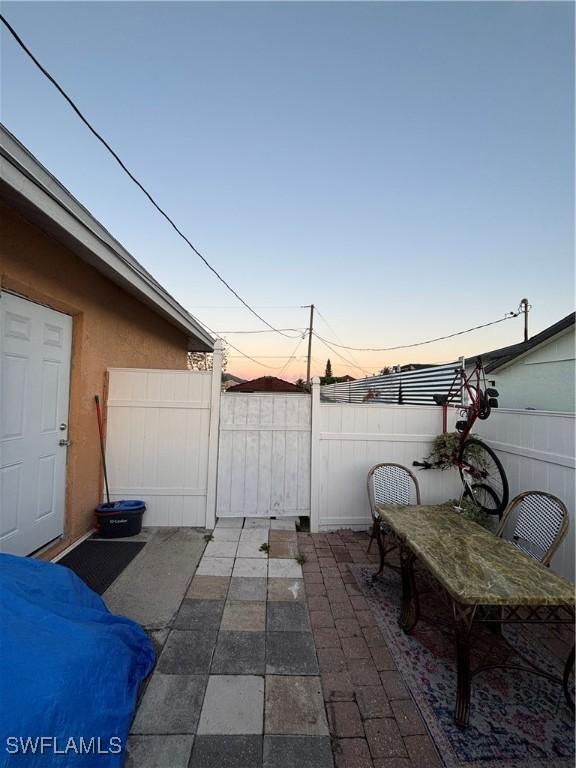 patio terrace at dusk featuring fence