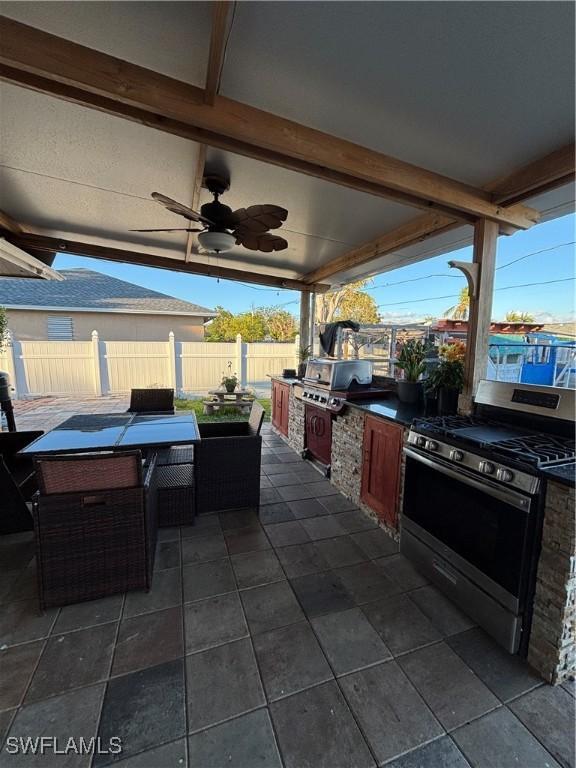 view of patio / terrace featuring outdoor dining area, area for grilling, fence, and a ceiling fan