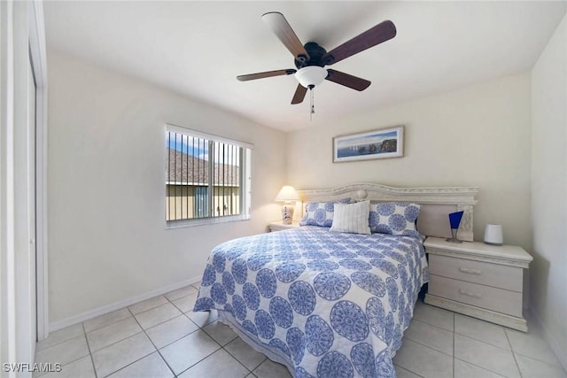 tiled bedroom with a ceiling fan and baseboards