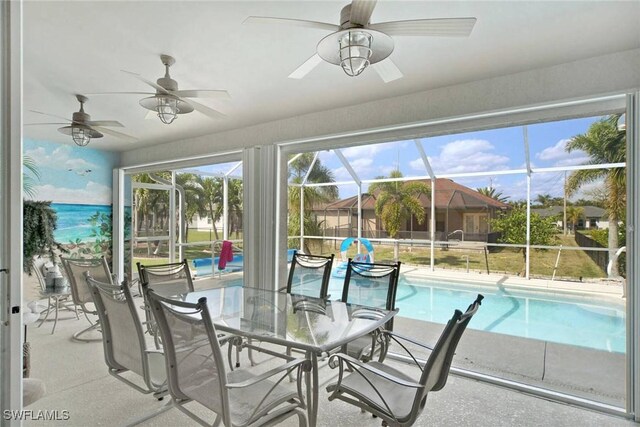 sunroom / solarium featuring a swimming pool and a ceiling fan