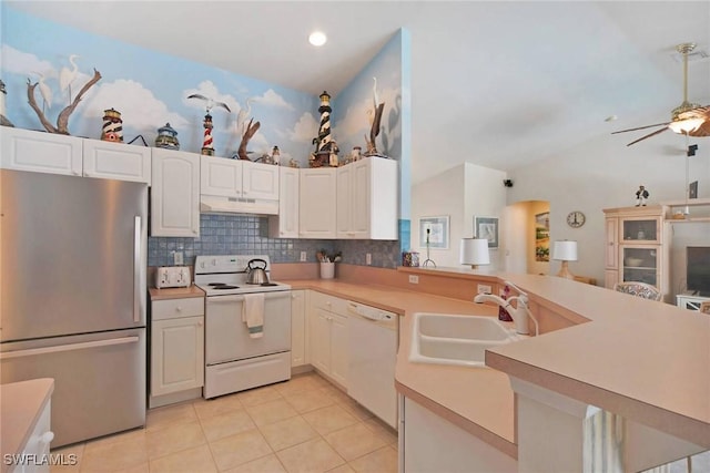 kitchen with light countertops, a sink, a peninsula, white appliances, and under cabinet range hood