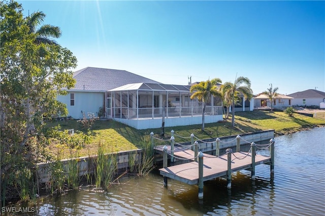 dock area featuring glass enclosure, a yard, and a water view