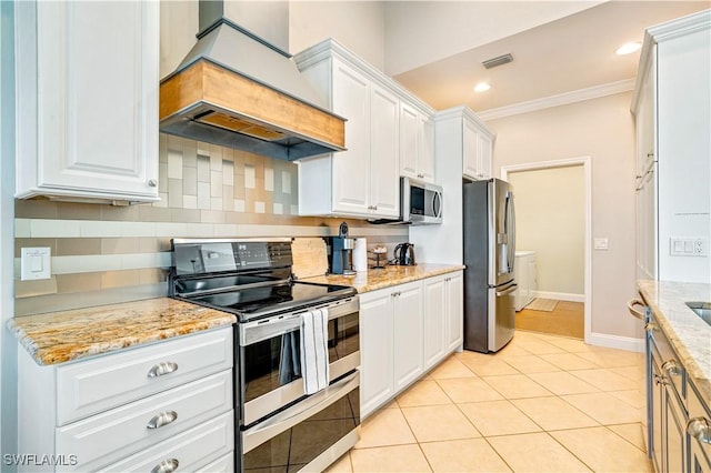 kitchen featuring tasteful backsplash, white cabinetry, stainless steel appliances, and custom range hood