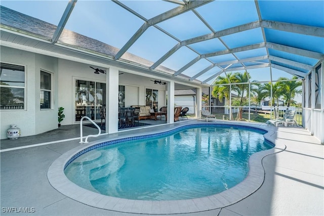 outdoor pool with ceiling fan, outdoor lounge area, glass enclosure, and a patio