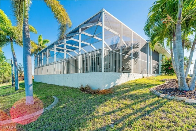 view of side of property with glass enclosure and a lawn