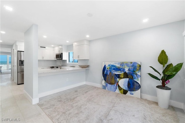 kitchen featuring stainless steel appliances, recessed lighting, light countertops, white cabinetry, and a peninsula