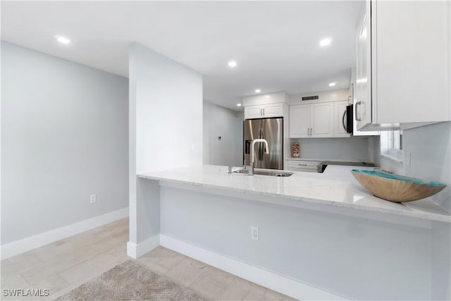 kitchen with baseboards, white cabinets, stainless steel fridge with ice dispenser, light stone counters, and a peninsula