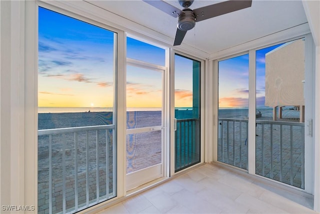 unfurnished sunroom featuring a ceiling fan