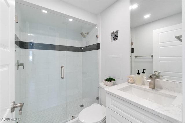 bathroom featuring a stall shower, vanity, and toilet