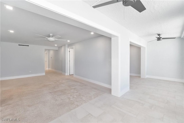 empty room with a ceiling fan, a textured ceiling, and baseboards