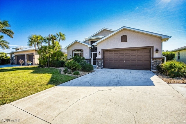 view of front of house with a garage, a front yard, stone siding, and stucco siding