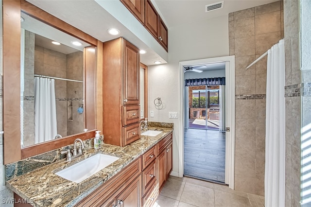 full bathroom with tile patterned flooring, visible vents, a sink, and tiled shower