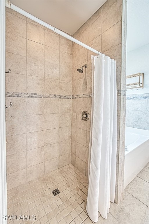 bathroom with tile patterned flooring, a shower stall, and a bath