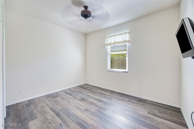 empty room with a ceiling fan, baseboards, and wood finished floors