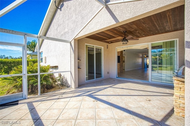 view of patio with glass enclosure and ceiling fan