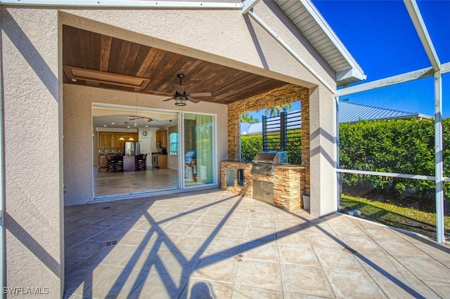 view of patio with a lanai, an outdoor kitchen, grilling area, and a ceiling fan