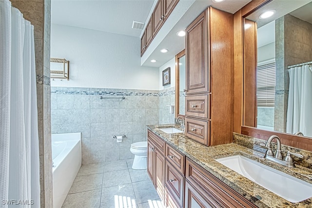 full bath featuring toilet, a sink, visible vents, and tile walls