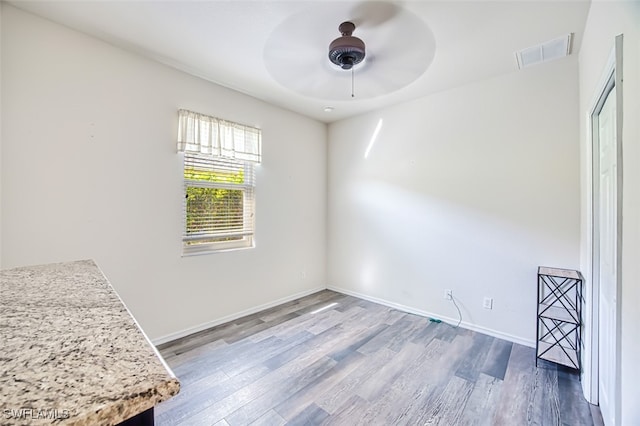 empty room with visible vents, baseboards, and wood finished floors