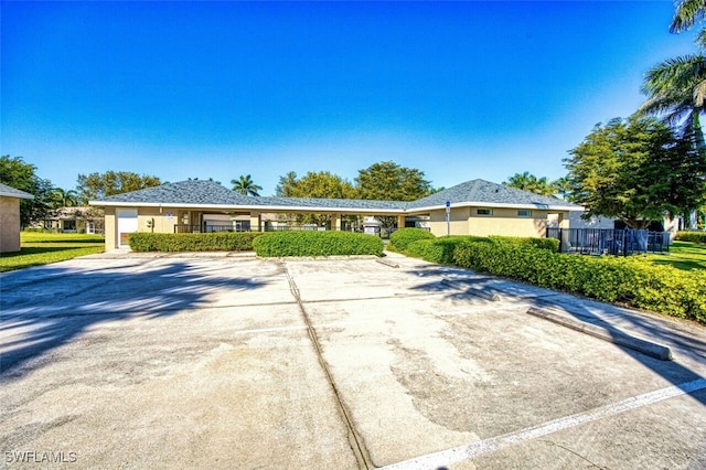 ranch-style house with fence and stucco siding