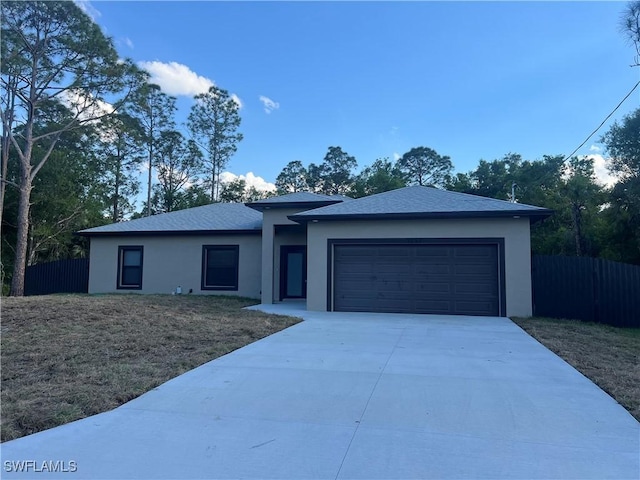 view of front of property with a garage, driveway, fence, and stucco siding