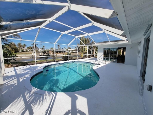 outdoor pool featuring a patio and glass enclosure