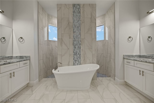 bathroom featuring marble finish floor, a soaking tub, walk in shower, and vanity