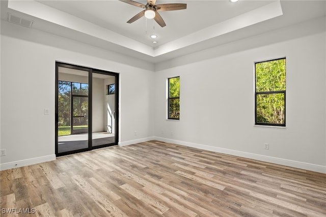 unfurnished room featuring baseboards, visible vents, and a wealth of natural light