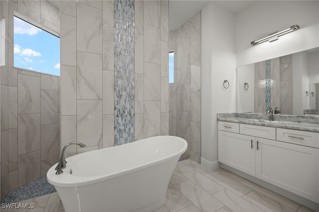 full bath with a freestanding bath, marble finish floor, and vanity