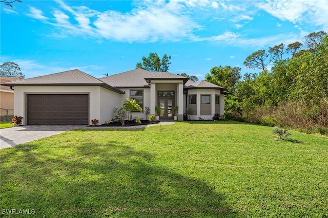 prairie-style home with decorative driveway, french doors, stucco siding, a garage, and a front lawn