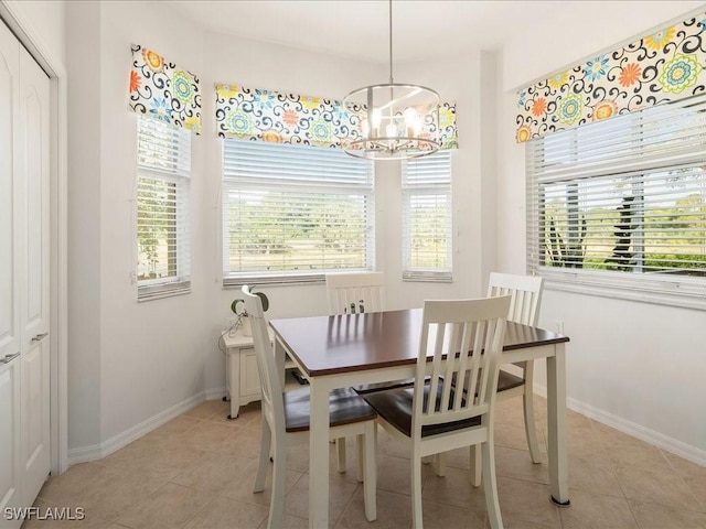 dining area featuring a healthy amount of sunlight, a notable chandelier, baseboards, and light tile patterned floors