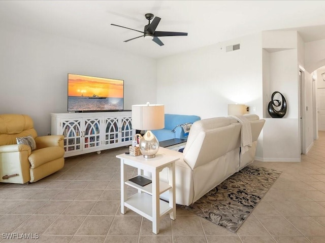 living room featuring tile patterned flooring, visible vents, and ceiling fan