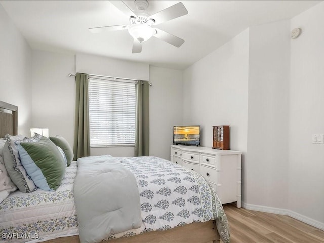 bedroom with a ceiling fan, light wood-type flooring, and baseboards